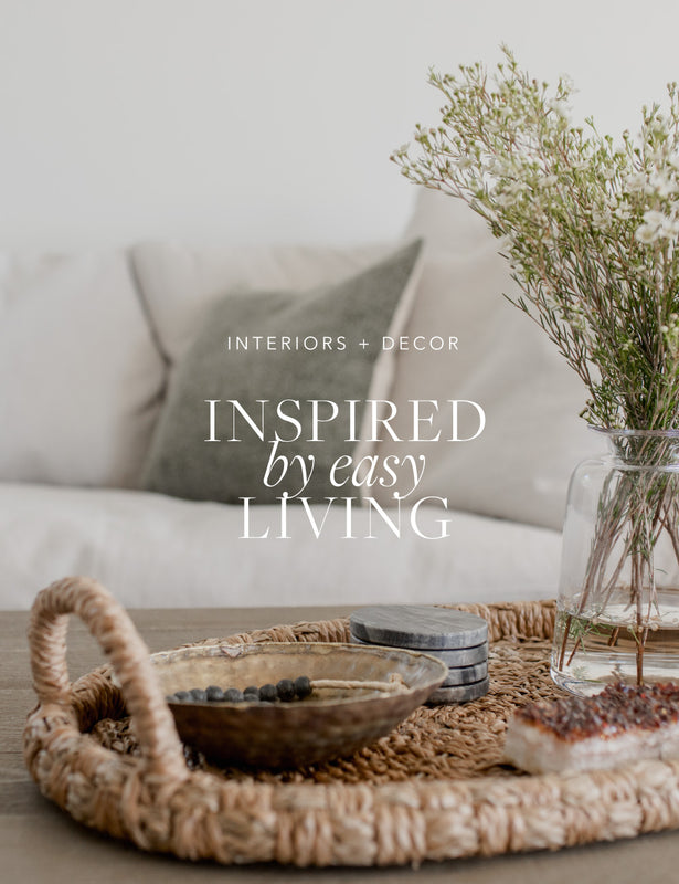 Lounge and coffee table setting with basket, flowers and crystal